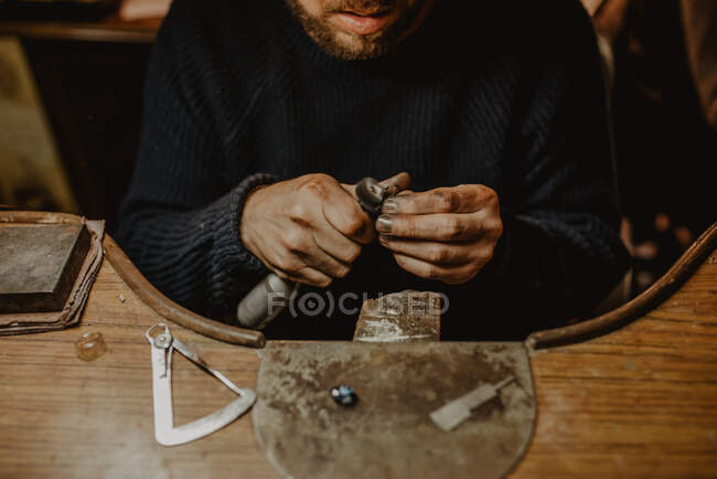 Joalheiro usando máquina de polimento profissional na bancada enquanto faz anel de metal na oficina — Fotografia de Stock
