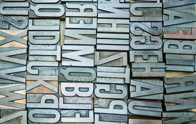 Вид зверху набір металевих шорстких літерпрес, розміщених у дерев'яній коробці в типографії — стокове фото