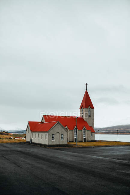 Kleine katholische Kirche bei regnerischem Wetter und bewölktem Himmel — Stockfoto