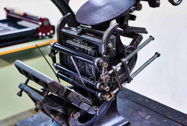 Retro shabby letterpress machine with metal details placed on wooden workbench in typography — Stock Photo