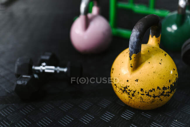 Set di kettlebell colorati e manubri di vari pesi posizionati sul pavimento del moderno centro fitness — Foto stock