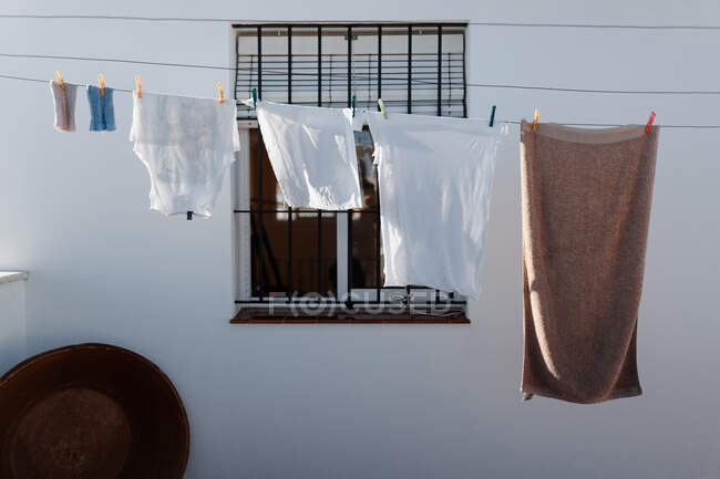 Lavado lavanderia pendurada no varal no quintal da casa de campo com paredes brancas e janela de grade — Fotografia de Stock