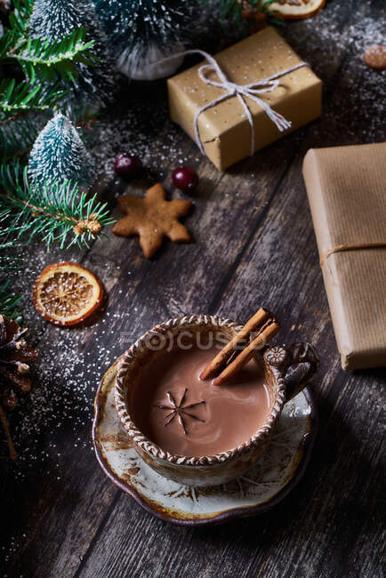 Du dessus bol de chocolat avec décoration de Noël sur table en bois à côté de cadeaux emballés — Photo de stock