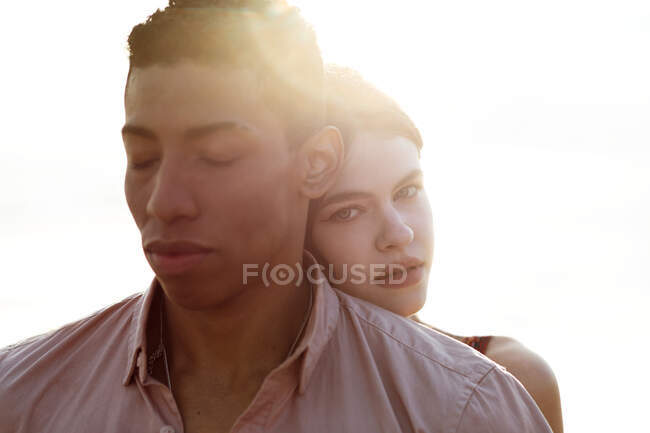 Mulher amorosa abraçando o homem negro por trás enquanto passavam o dia de verão juntos na praia — Fotografia de Stock