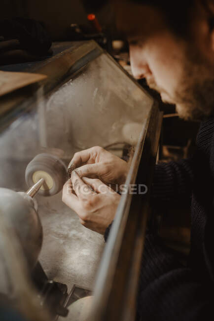 Mãos de ourives masculinos anônimos usando ferramenta manual para moldar anel de metal na oficina — Fotografia de Stock