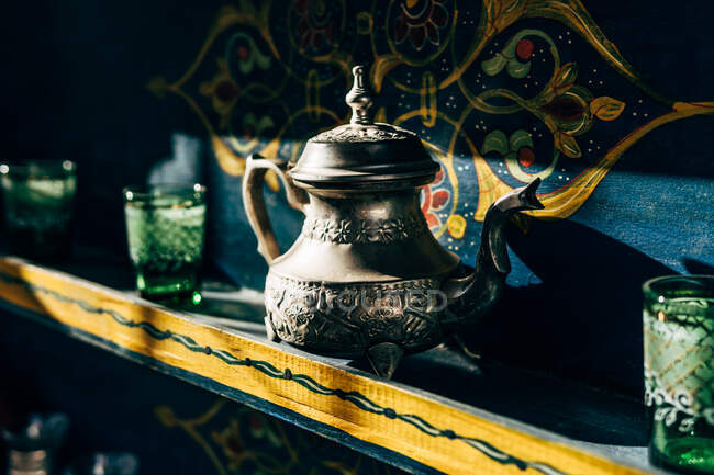 Chaleiras de cerâmica e metal com copos pequenos copos em prateleiras coloridas em Marrocos — Fotografia de Stock