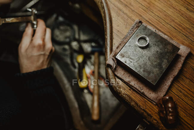 Ourives masculinos usando ferramenta manual para moldar anel de metal na oficina — Fotografia de Stock