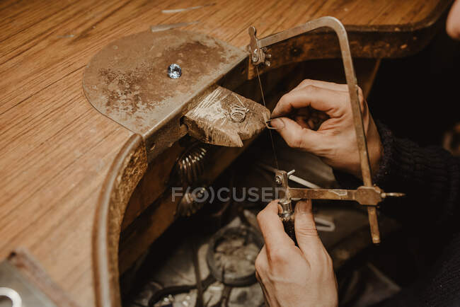 Goldsmith corte de metal com serra ao fazer jóias na oficina — Fotografia de Stock