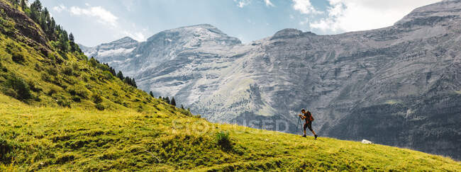 Panoramic side view of unrecognizable men hiking green mountain in the Dolomites, Italy — Stock Photo