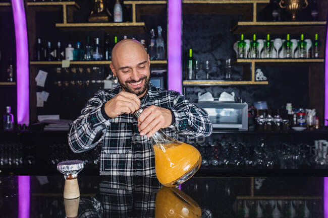 Homem feliz preparando um grande copo narguilé tradicional em uma boate — Fotografia de Stock