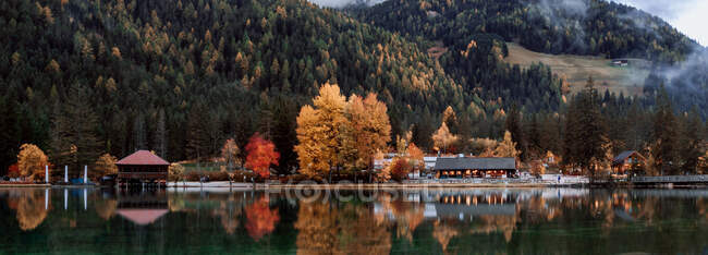 Landscape with lake and settlement reflection on autumn season in Dolomites, Italy — Stock Photo