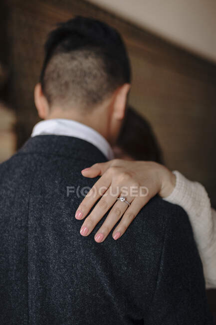 Unrecognizable bride with delicate wedding ring on finger keeping hand on shoulder of beloved husband during wedding dance — Stock Photo