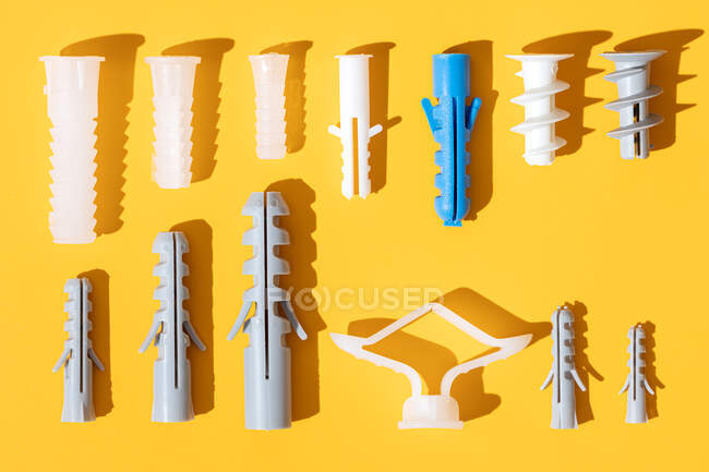 Ansicht von Kunststoffdübeln unterschiedlicher Größe mit Löchern auf gerippter Oberfläche in Reihe — Stockfoto