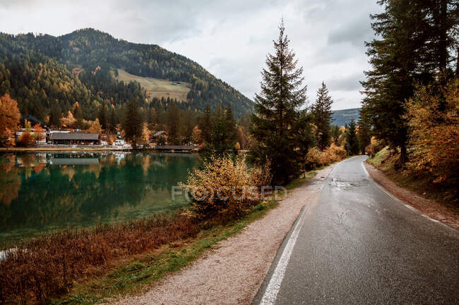 Landschaft mit Straße am See und Siedlungsreflexion über die Herbstsaison in den Dolomiten, Italien — Stockfoto