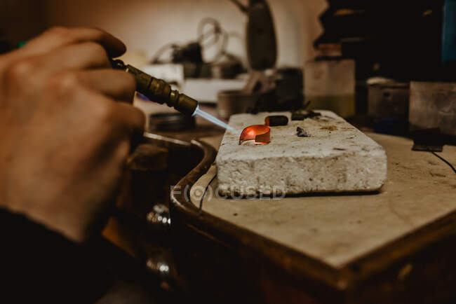 Anonymer Goldschmied hämmert und expandiert Ring Rohling auf Metallstab während der Arbeit in der Werkstatt — Stockfoto