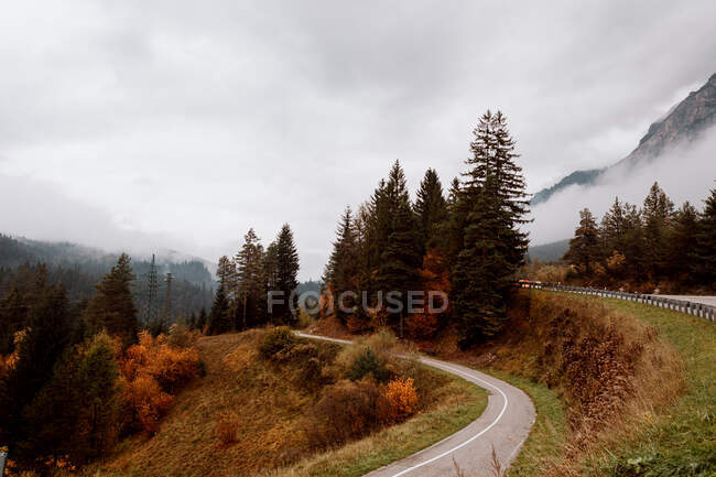 Paesaggio con strada lungo la montagna autunnale nelle Dolomiti — Foto stock