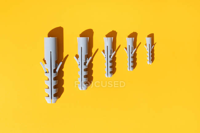 Ansicht von Kunststoffdübeln unterschiedlicher Größe mit Löchern auf gerippter Oberfläche in Reihe — Stockfoto