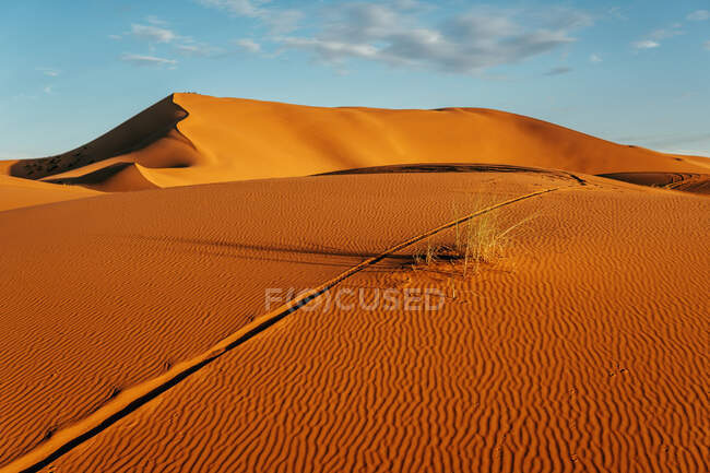 Dall'alto del deserto vuoto colorato con grandi dune sotto il cielo blu nuvoloso in Marocco — Foto stock