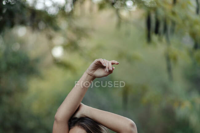 Врожай спокійний розслаблена жінка піднімає руку, насолоджуючись літнім днем у зеленому лісі — стокове фото