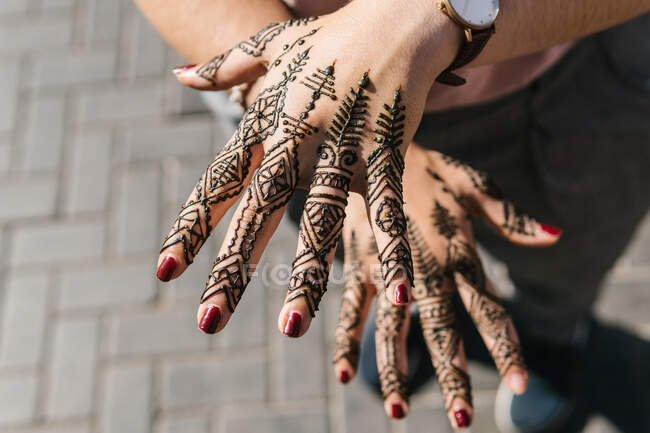 From above of crop female palms with black exotic patterns on blurred background in Morocco — Stock Photo
