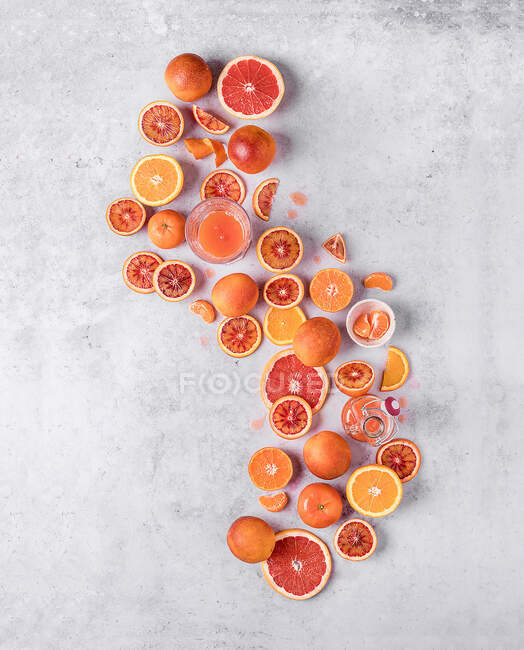 Vista superior de la fruta sanguina en la mesa blanca cortada en mitades - foto de stock