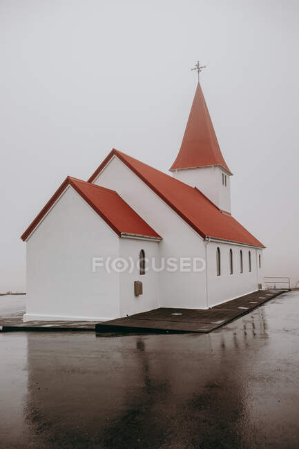 Маленькая католическая церковь в дождливую погоду и облачное небо — стоковое фото