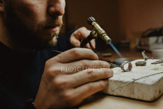 Oreficeria con fiamma ossidrica per riscaldare minuscoli ornamenti metallici mentre si realizzano gioielli sul banco da lavoro — Foto stock