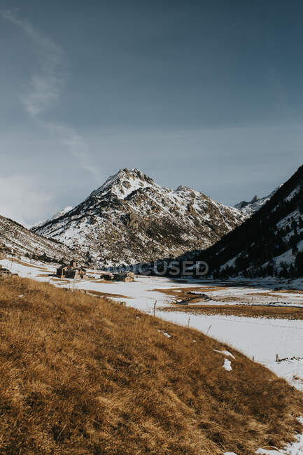 Terras selvagens entre colinas de pedra na neve no dia ensolarado — Fotografia de Stock
