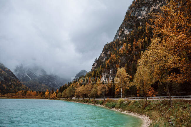 Paisaje con carretera a lo largo del lago en la temporada de otoño en Dolomitas, Italia - foto de stock