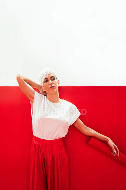 Mujer joven en ropa blanca y roja de moda mirando hacia otro lado sobre  fondo de dos colores — con estilo, Vibrante - Stock Photo | #511442404