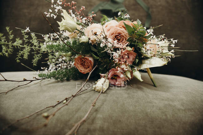 Decoração de casamento romântico festivo com bouquet delicado com rosa macio e rosas brancas com folhagem colocada em pano verde na mesa — Fotografia de Stock
