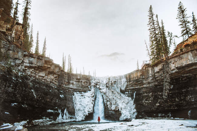 Tourist admiring Crescent Falls waterfall on cold winter day in Banff National Park — Stock Photo
