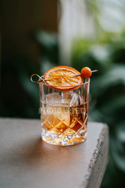 Zusammensetzung aus kaltem, eisigem Whisky, garniert mit Zitronenscheibe und auf einen Betontisch gelegt — Stockfoto