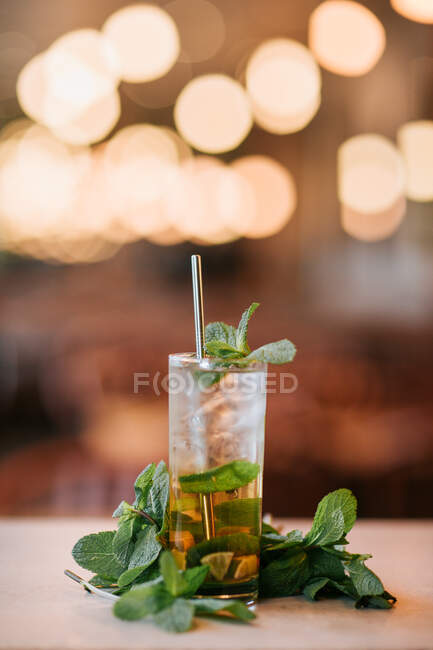 Kalter Mojito-Cocktail aus Rum-Limette und Minzblättern, serviert mit Eiswürfeln und wiederverwendbarem Stroh — Stockfoto