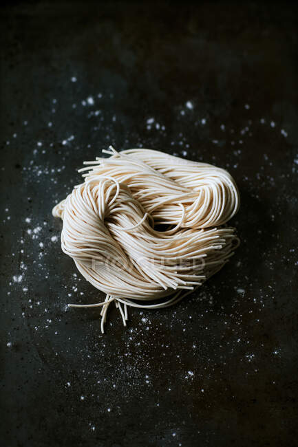 Top view of uncooked noodles for ramen preparation placed on dark background — Stock Photo