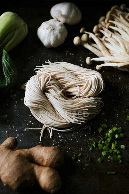 Vista superior de ingredientes variados para una sabrosa preparación de ramen colocada en la cocina - foto de stock