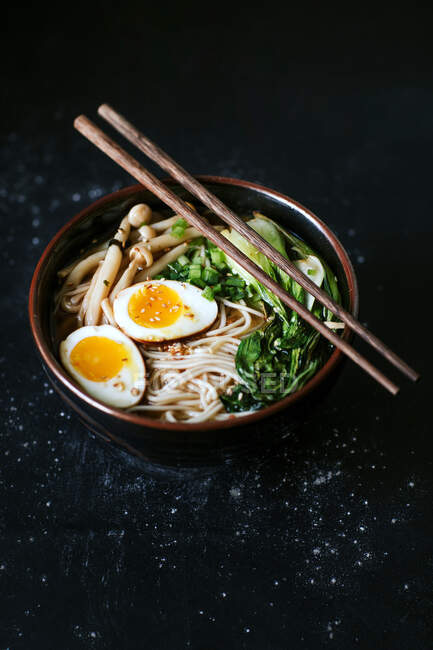 Top view of ceramic bowl with delicious ramen and chopsticks placed on table — Stock Photo