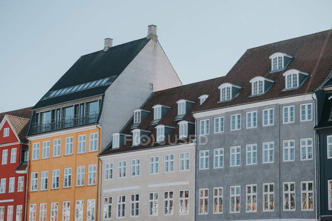 De baixo de tijolo brilhante e edifícios de apartamentos de pedra contra céu azul sem nuvens em Copenhague — Fotografia de Stock
