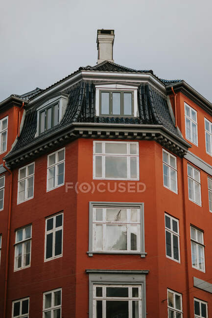 De baixo tijolo colorido e prédio de apartamentos de pedra contra céu azul sem nuvens em Copenhague — Fotografia de Stock