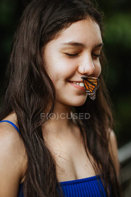 Joyeux jeune voyageuse avec beau papillon coloré sur le visage profitant de la nature pendant les vacances d'été au Costa Rica — Photo de stock