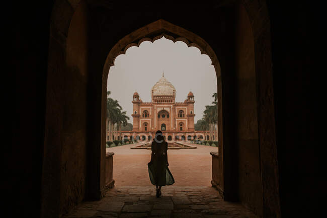 Ganzkörperrückseite Silhouette anonymer Touristin bewundert historisches Gebäude von Safdarjungs Grab in Neu Delhi — Stockfoto