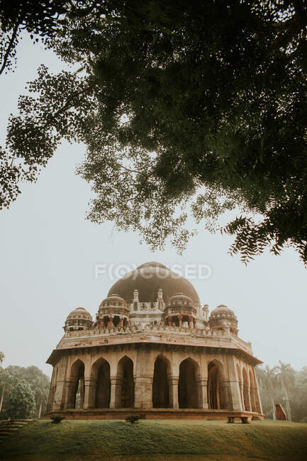 Low angle of historic Mohammed Shahs tomb with columns located in garden with trees — Stock Photo