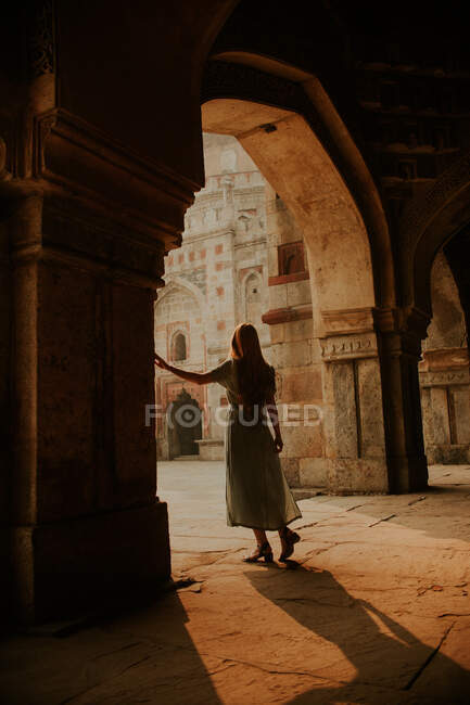 Corpo inteiro de volta vista de turista fêmea anônima em pé sob passagem arqueada de Muhammad Shah Sayyid túmulo em Lodhi Garden em Nova Deli — Fotografia de Stock