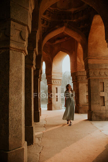Полное тело женщины-туриста, любовавшейся арками выдержанного каменного здания, расположенного в саду Лоди во время отдыха в Индии — стоковое фото