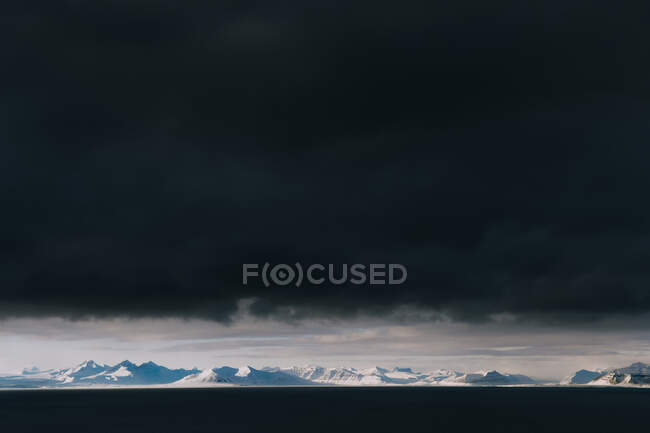 Spektakuläre Landschaft aus schneebedecktem Hochland unter dunklem Gewitterhimmel im Winter in Spitzbergen — Stockfoto