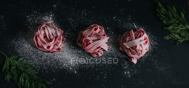 Stuzzicante pasta vegana di barbabietola di colore rosa servita sul tavolo nero in studio — Foto stock