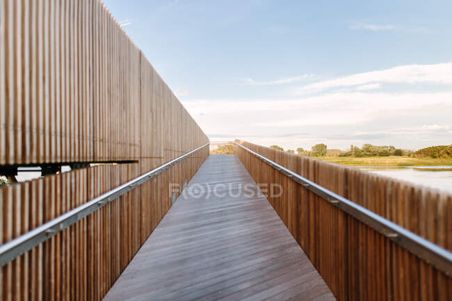 Modern wooden embankment located in countryside on sunny day in summer under blue sky — Stock Photo