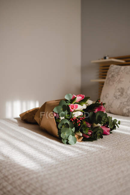 Incrível buquê de tulipas na cama em um quarto brilhante e ensolarado para namorados — Fotografia de Stock