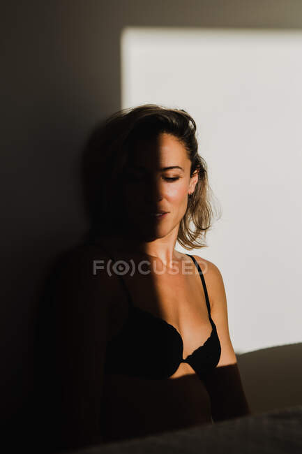 Sensual bonita mulher brincando entre luz e sombra em lingerie — Fotografia de Stock