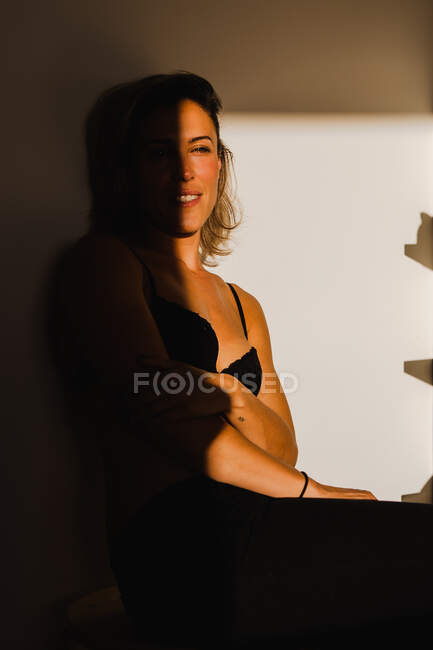 Чуттєва красива жінка грає між світлом і тіні в нижній білизні — стокове фото